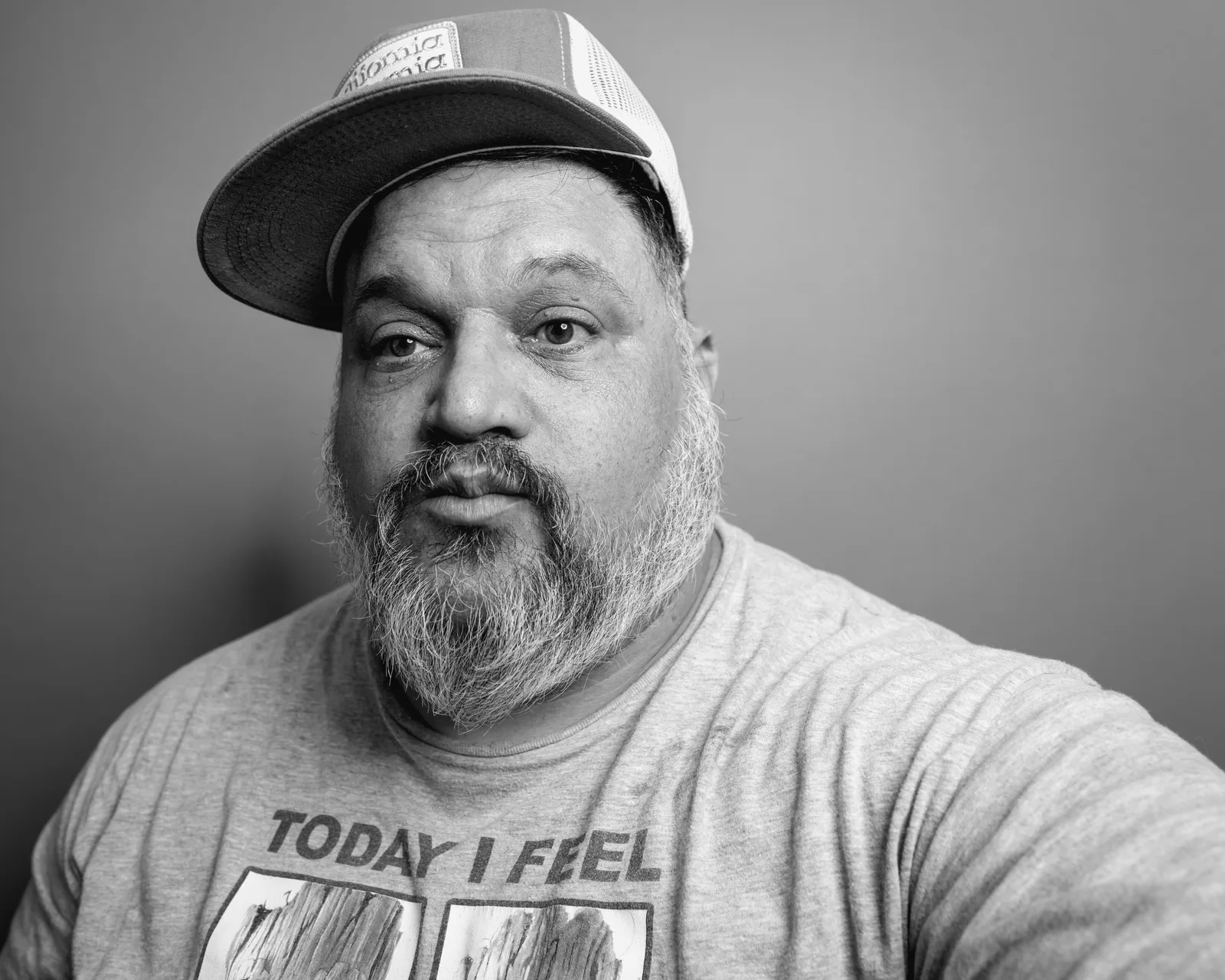 Black-and-white close-up of a bearded man in a gray T-shirt reading "TODAY I FEEL" above small illustrated panels.